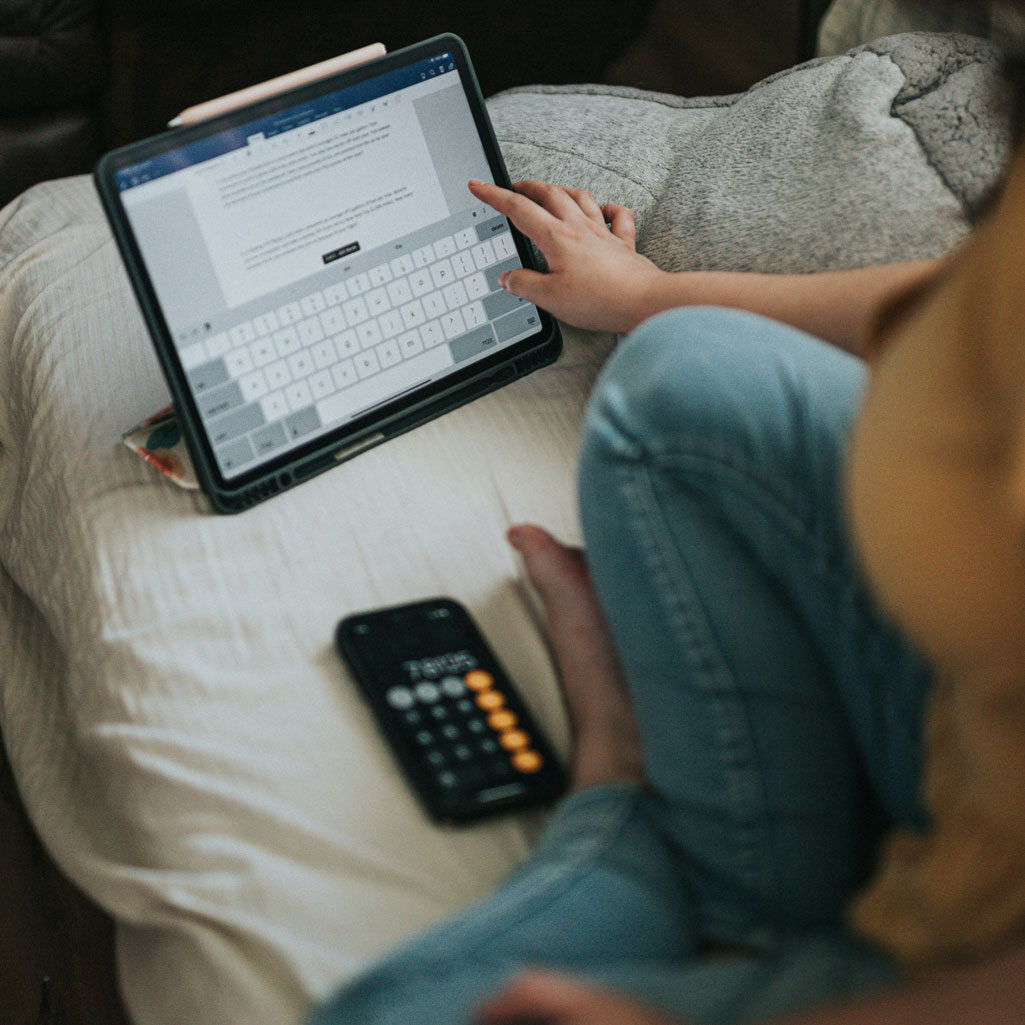 woman working on tablet with calculator